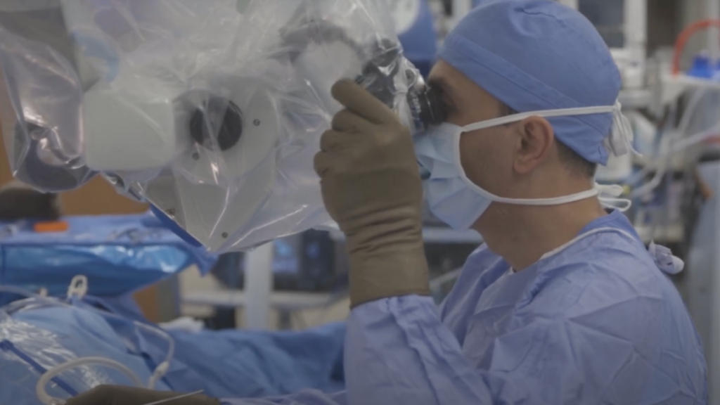 A surgeon using a medical device in an operating room.